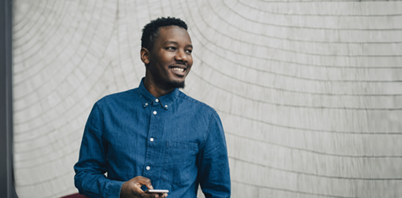 Your man smiling and holding phone in hand.