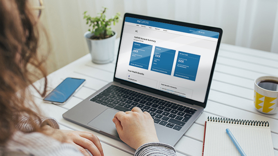 Woman sitting in front of laptop on table with web browser open showing the myCalPERS website