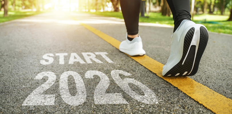 Person running down the street with the phrase "2026 Start" imprinted on the ground