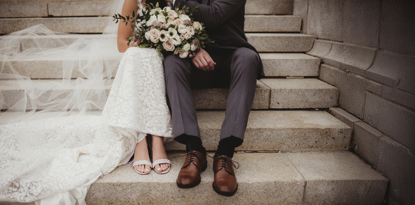 Married couple, faces obscured, sitting on steps