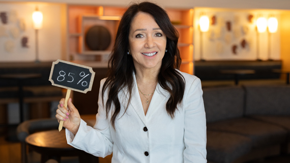Marcie Frost holding a sign that reads ‘84%
